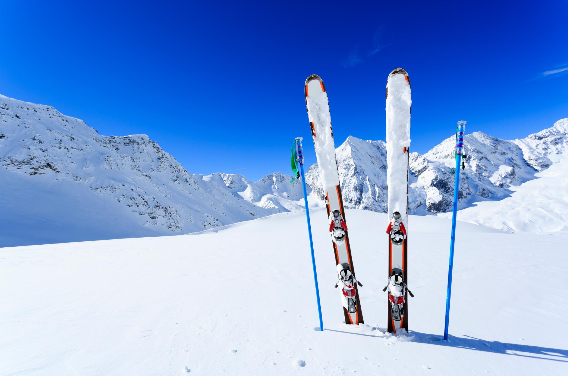 Im Schnee steckende Skier mit blauem Himmel
